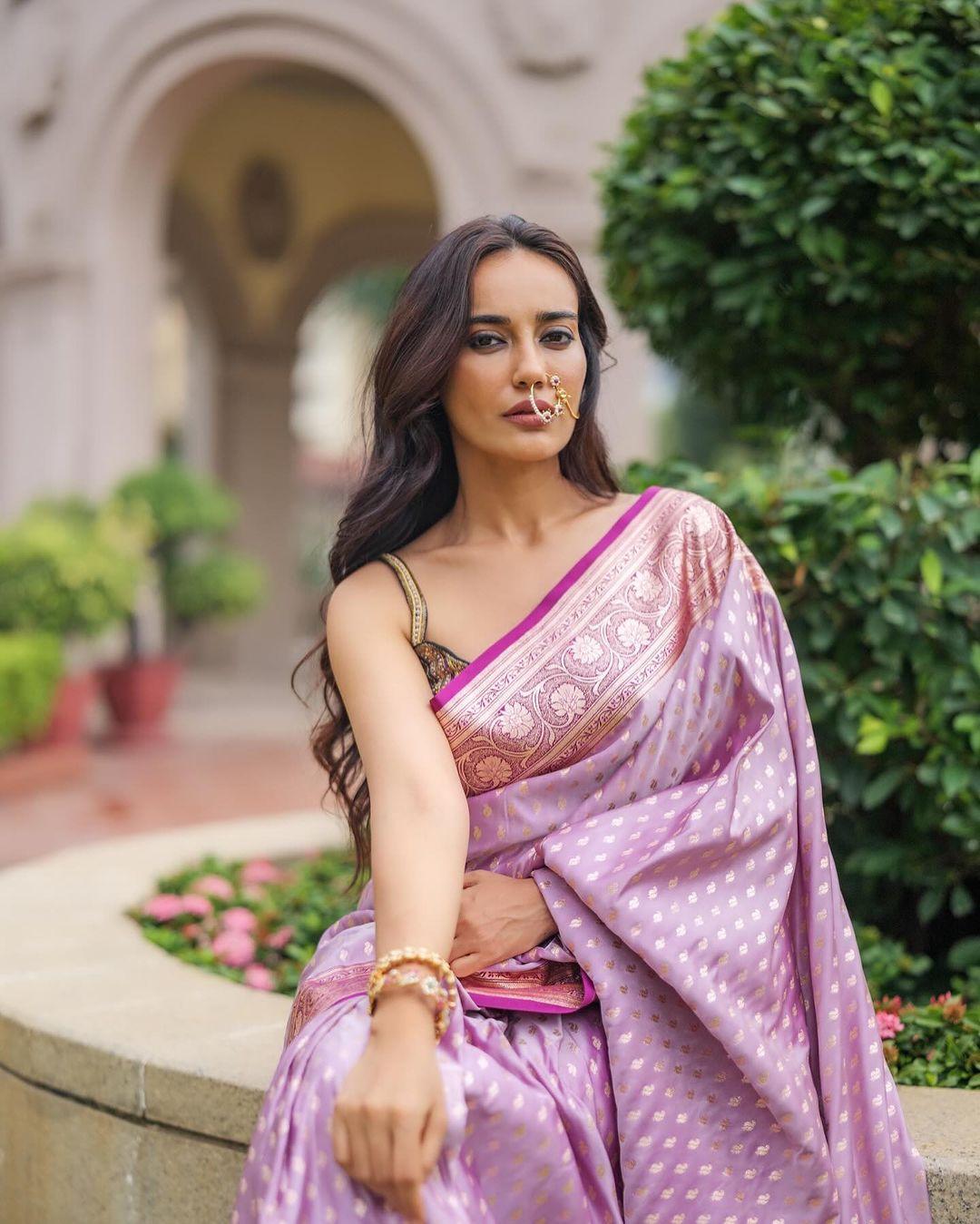 Draped in a printed purple saree paired flawlessly with a dark-coloured blouse, she radiated grace. If you're looking for a saree that is light yet classy for a puja, your search ends here