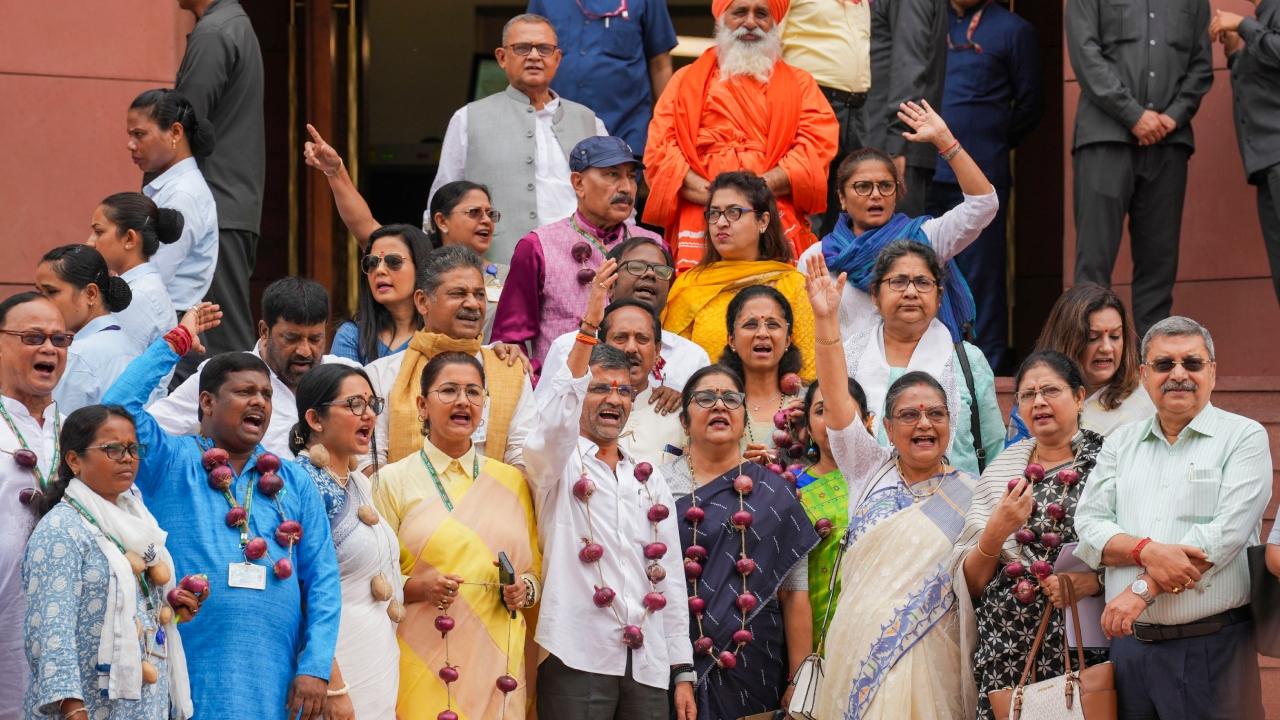 MPs from the Opposition wear garlands made of onions to stage a protest against the rise in prices of vegetables, in New Delhi, on Thursday 