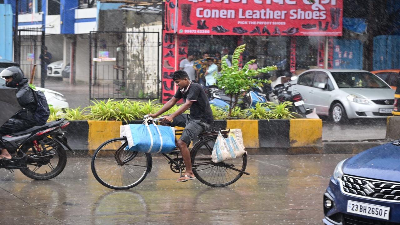 A cyclist caught off guard as rains lashed Dharavi on Saturday 