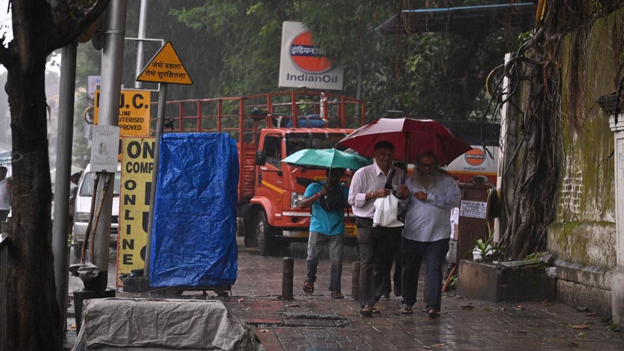 Sharing is caring: Two pedestrians share an umbrella in Parel. Some Mumbaikars were caught off guard as they did not anticipate heavy, continuous showers in the city on Saturday    