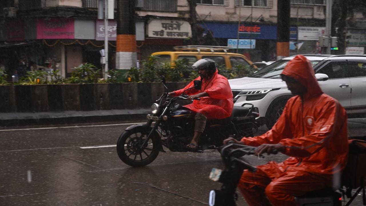 Food delivery app executives off to complete their orders amid the heavy downpour in Parel. Heavy rains made a comeback in Mumbai after a long interval  