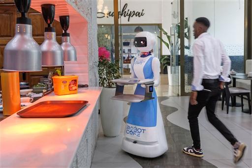 The humanoid awaits an order at the counter  