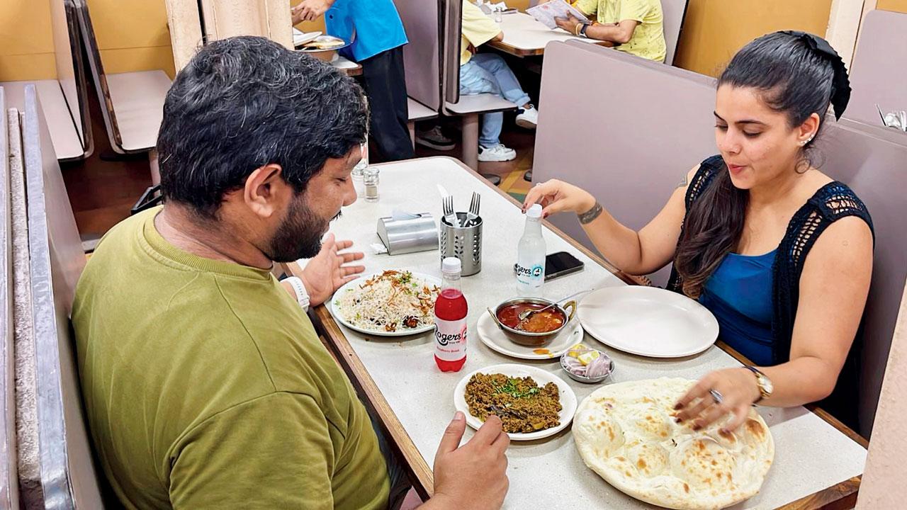 A patron enjoys the aerated drink with a meal at the Colaba restaurant