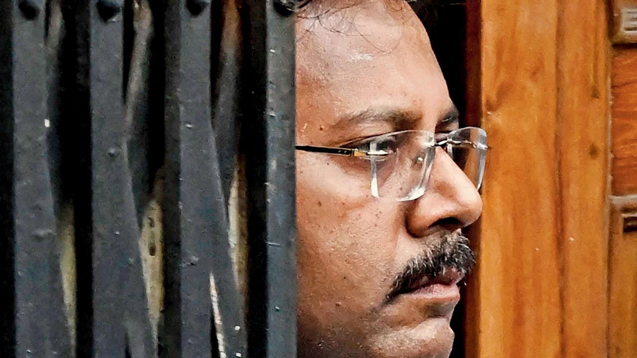 Ex-principal Sandip Ghosh looks on as CBI personnel raid his residence
