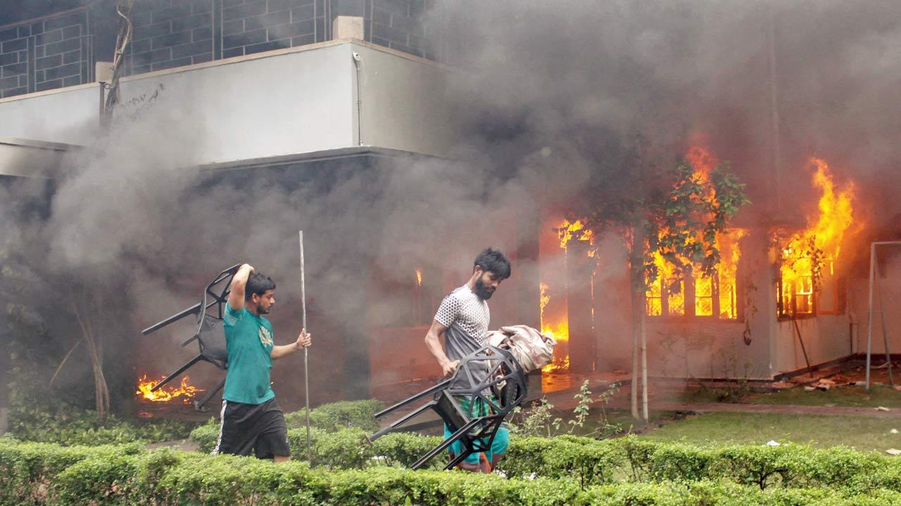 Protesters vandalise the Bangabandhu Memorial Museum as they set it on fire, in Dhaka, on Monday. Pic/PTI
