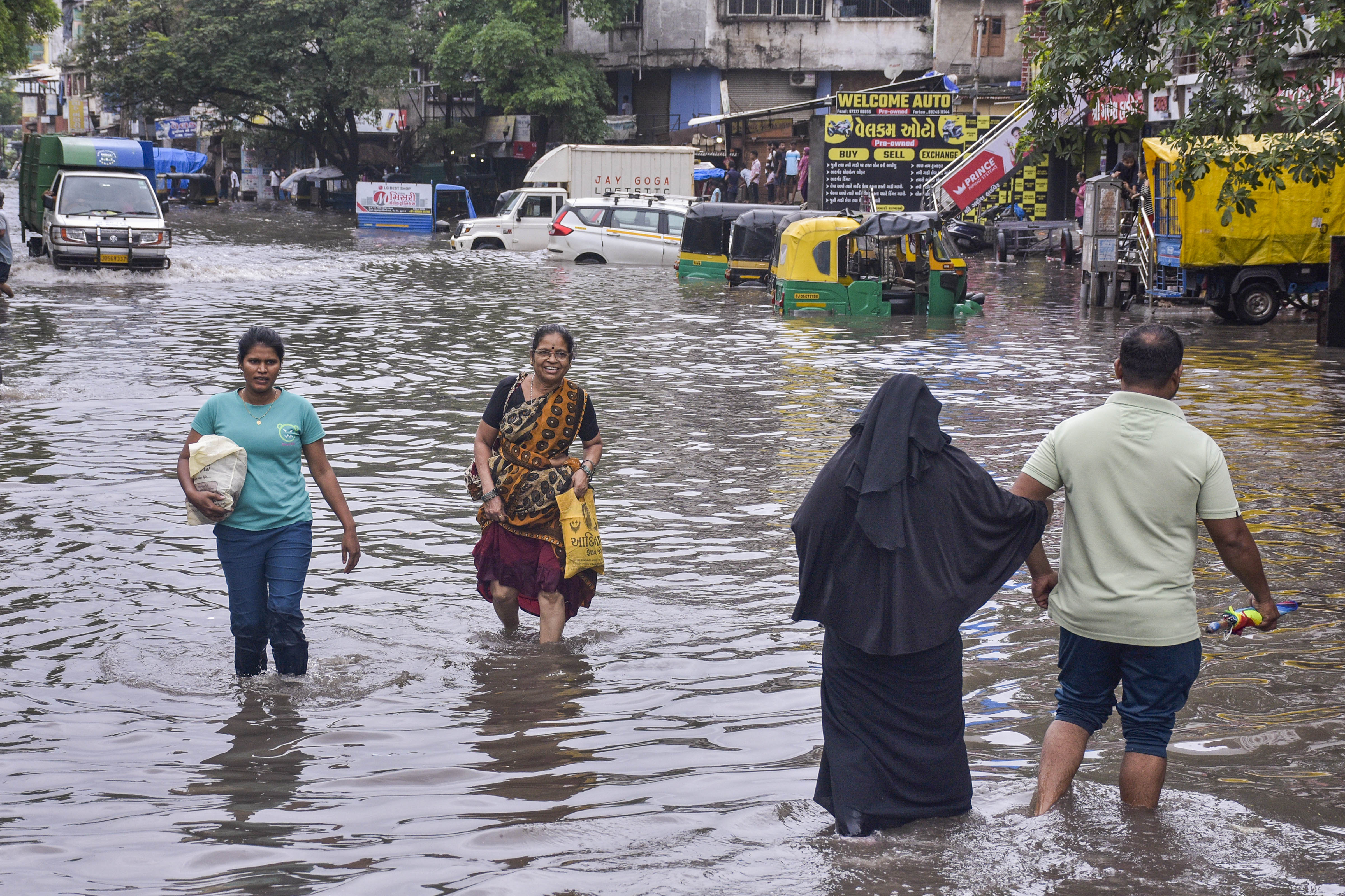 Residents in Surat wade through ankle-length water. The CMO has asked authorities to ensure that residents do not fall short of food, medicine and other essential supplies 