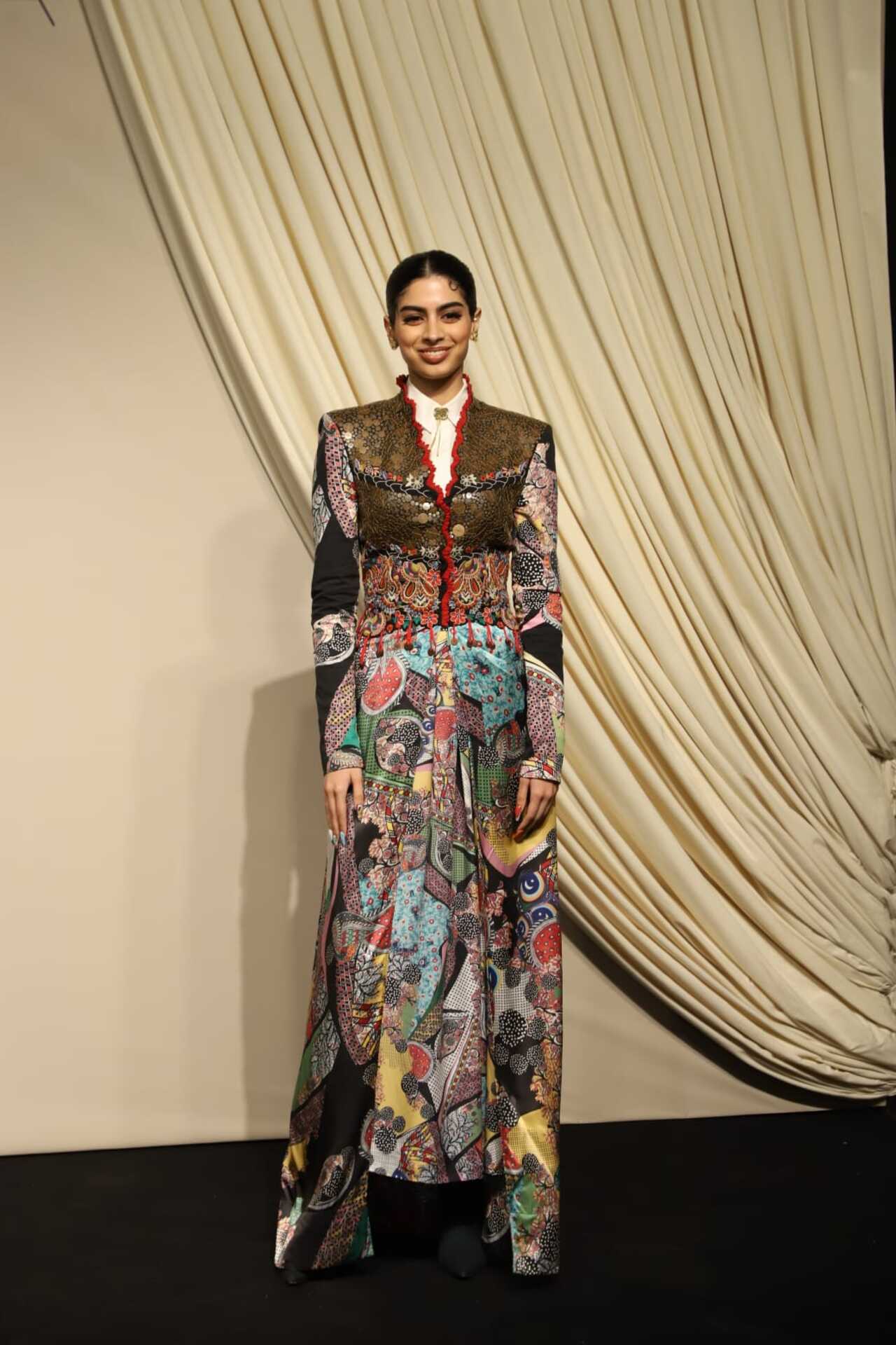 Khushi Kapoor stood out in this multi-coloured long coat which she paired with a white crisp collared shirt