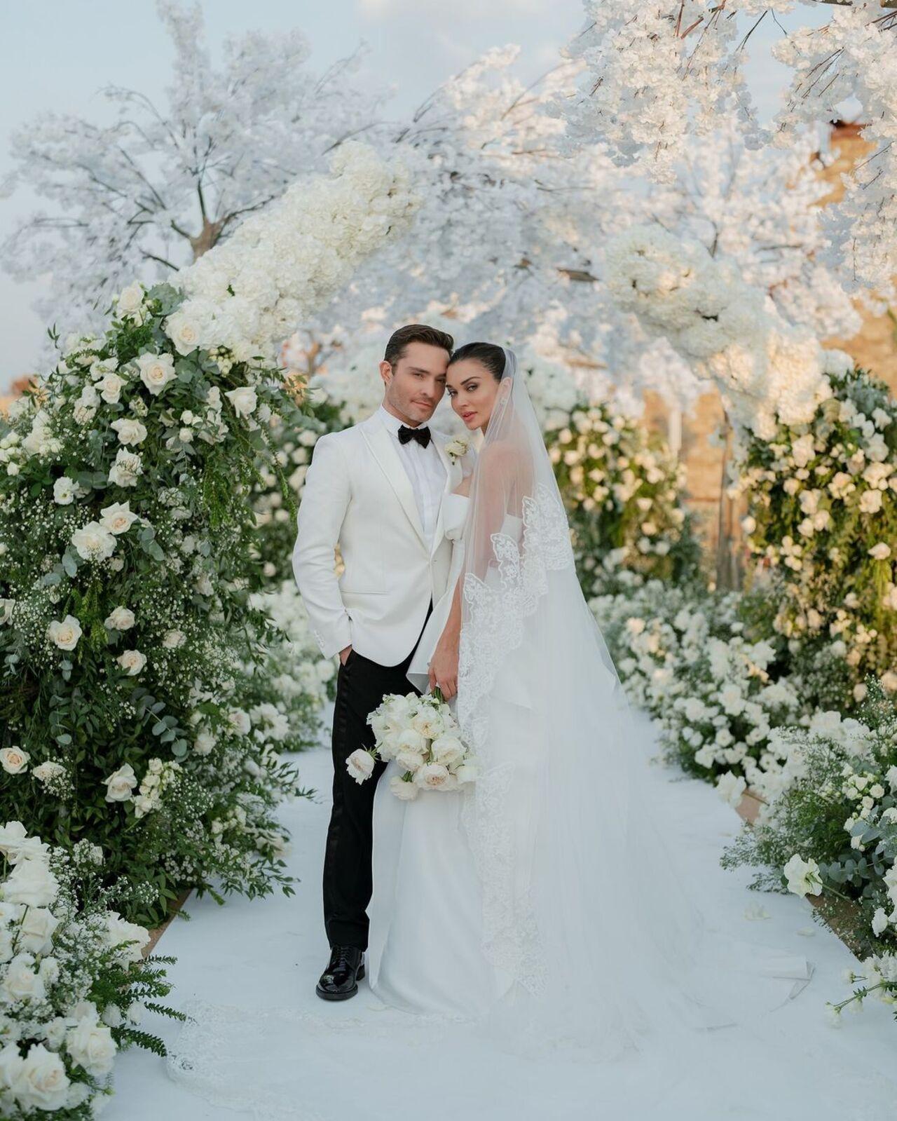 She carried a delicate bouquet of white roses, complementing the serene and sophisticated ambience of the ceremony
