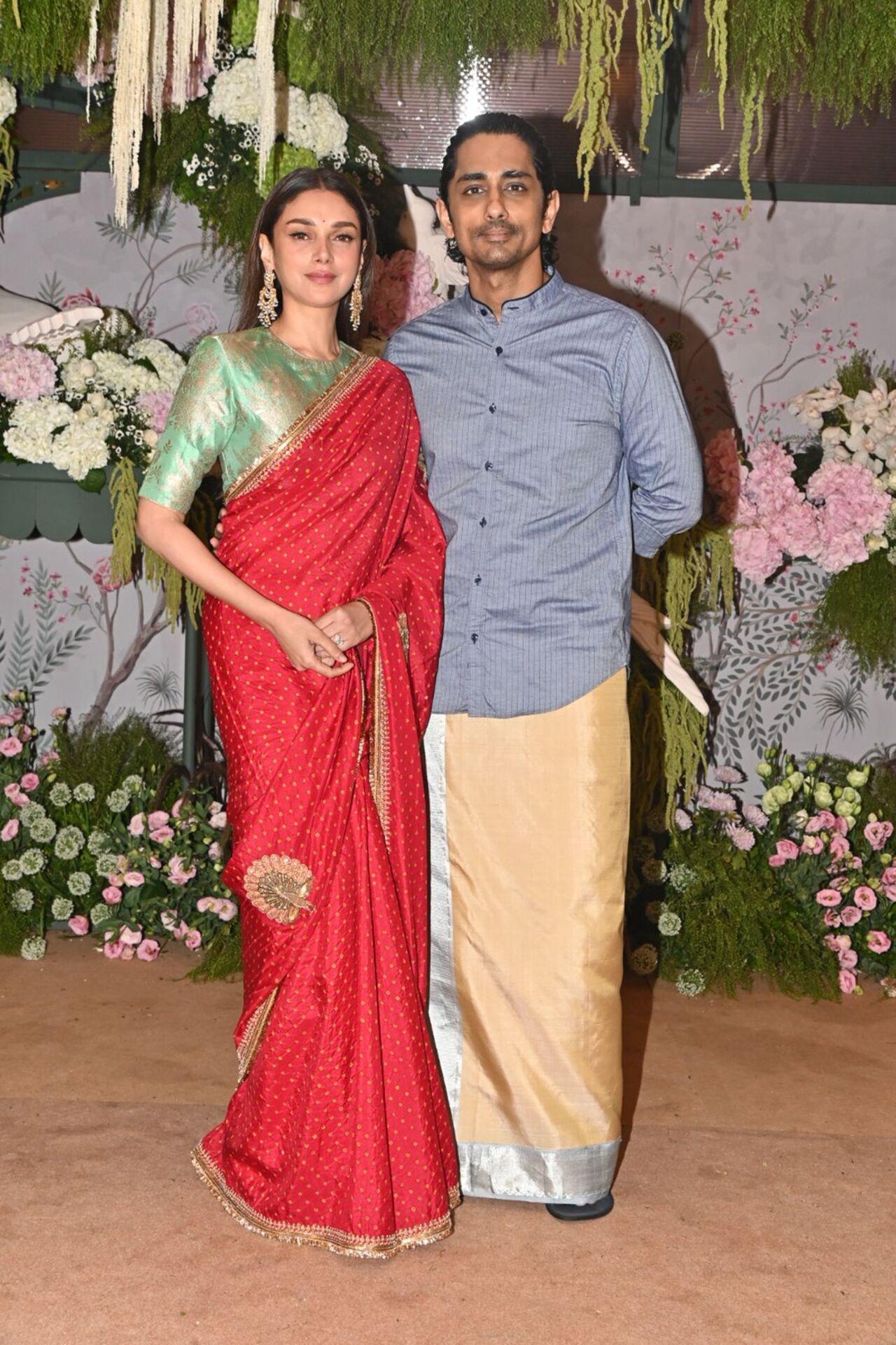 Aditi Rao Hydari stunned in a red saree which she paired with a green shirt blouse. Her fiance and actor Siddharth kept it simple in a shirt and veshti. 
