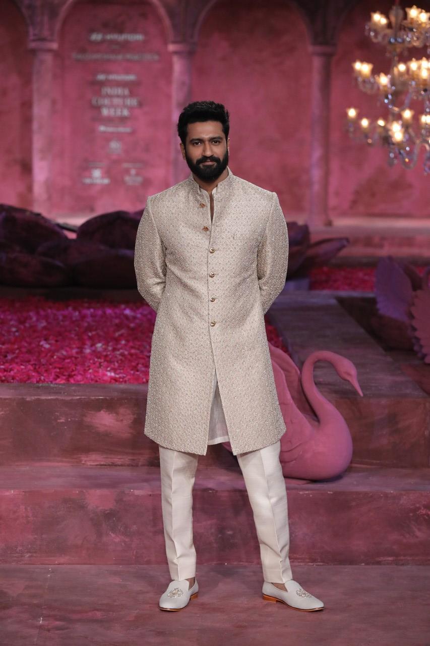 Vicky, on the other hand, embraced a regal aura with his pale golden dust sherwani, meticulously embellished with heavy sequined embroidery. The outfit was paired with powder-golden ivory pants and matching loafers, creating a harmonious and sophisticated look that exuded luxury and refinement.