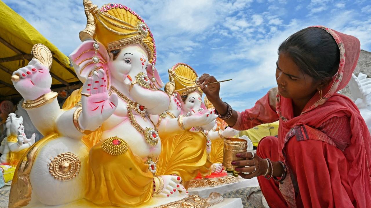 An artisan paints an idol of the Hindu deity Ganesha at a workshop ahead of the Ganesh Chaturthi festival, in Amritsar on August 27, 2024