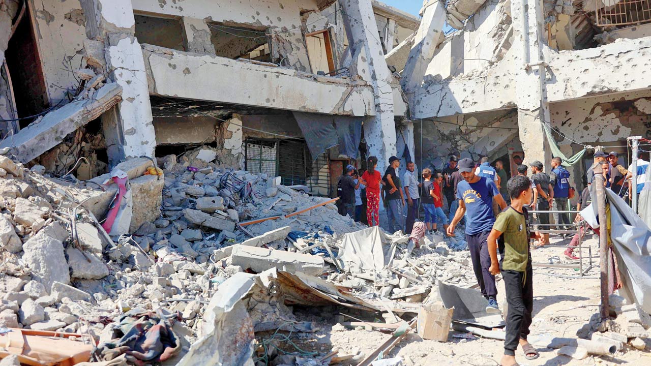 Locals check damage to a school in Gaza City. Pics/AFP