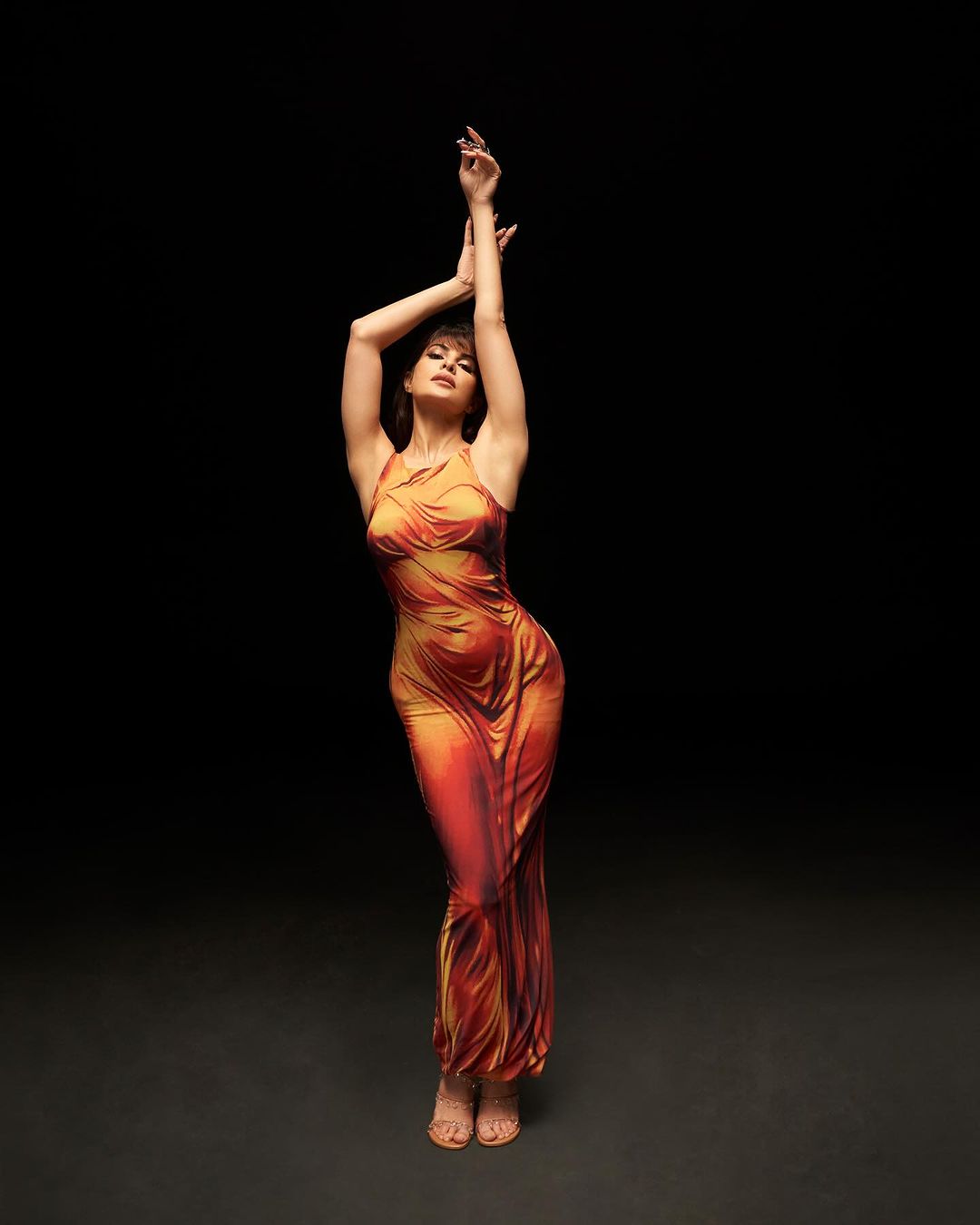 Jacqueline Fernandez rocked a figure-hugging Syndical Chamber Golden Blood Draped Dress for her hit song Yimmy Yimmy.
