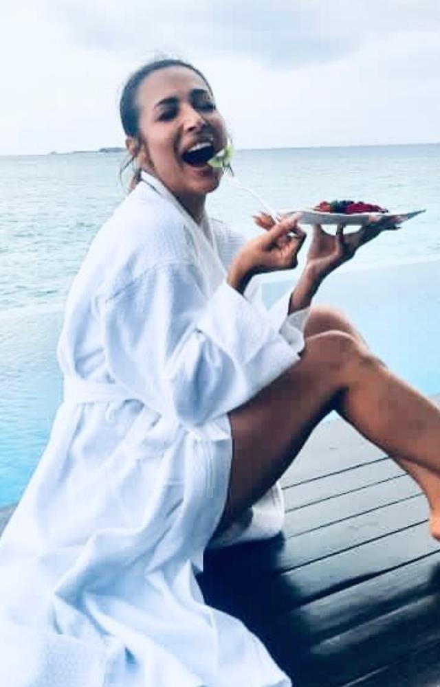 Here she enjoys her vacation like the way it should be done! Dressed in a bathrobe and munching on your favourite meal