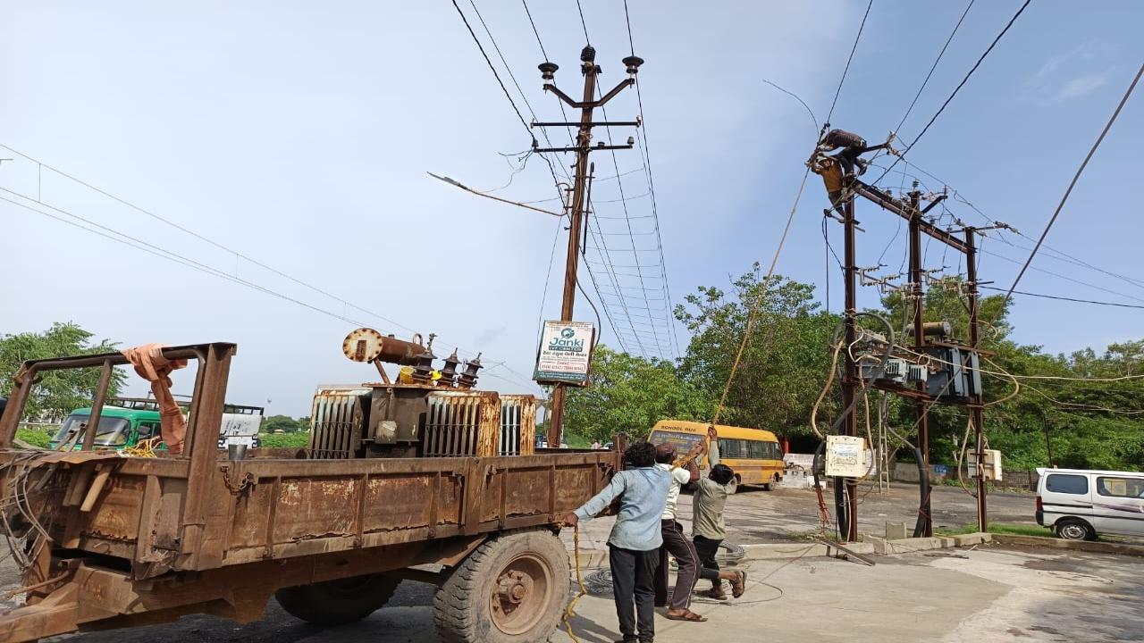 Workers fix the power lines in Morbi as waters recede  