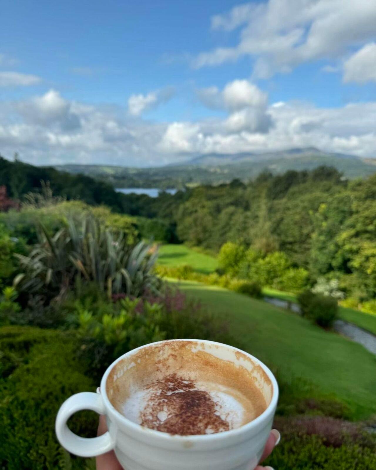 The first one is of her enjoying a hot cup of coffee while taking in the scenic beauty adorned with lush greenery. 