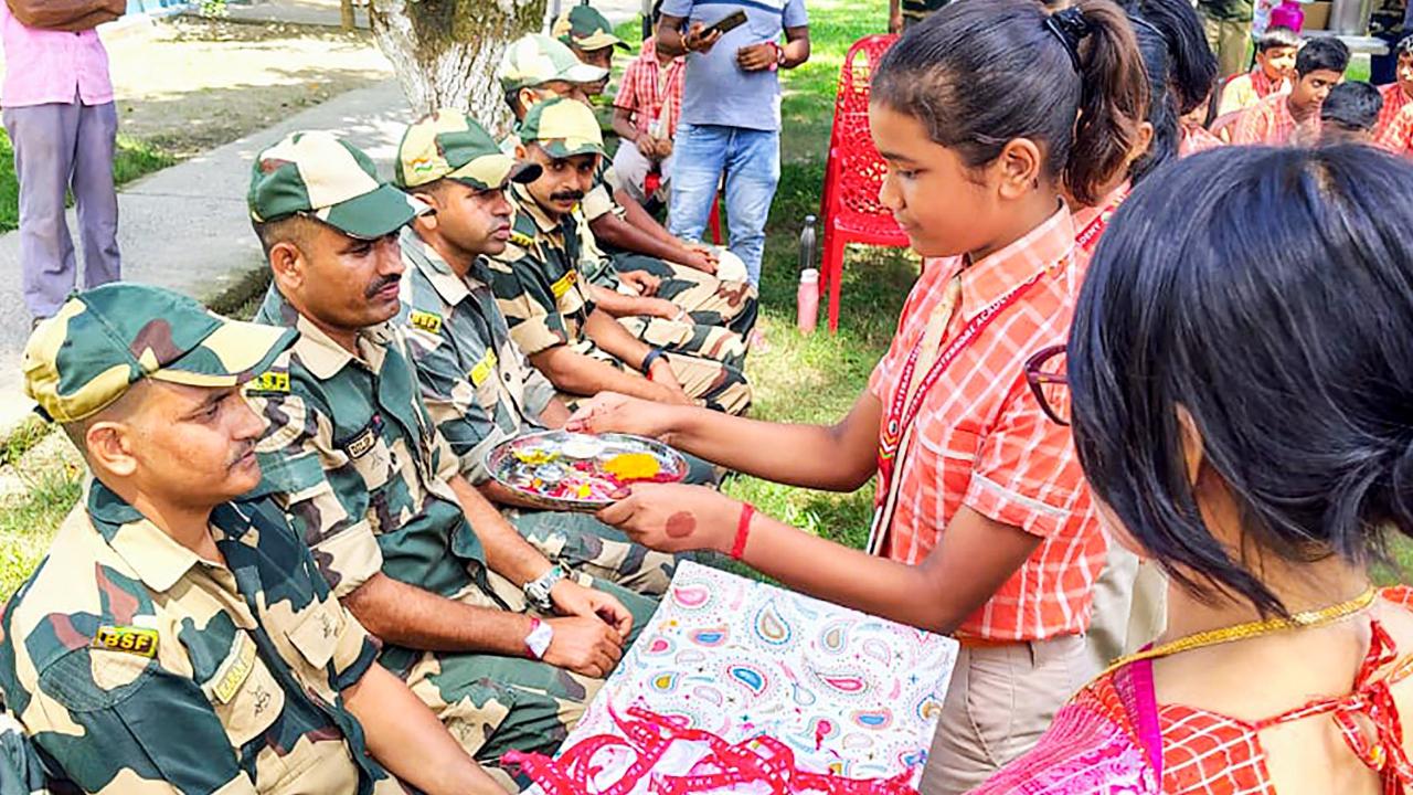 School children tie rakhis to BSF personnel on the occasion of Raksha Bandhan along the India-Bangladesh Border in South Dinajpur on Monday (Pic: ANI)