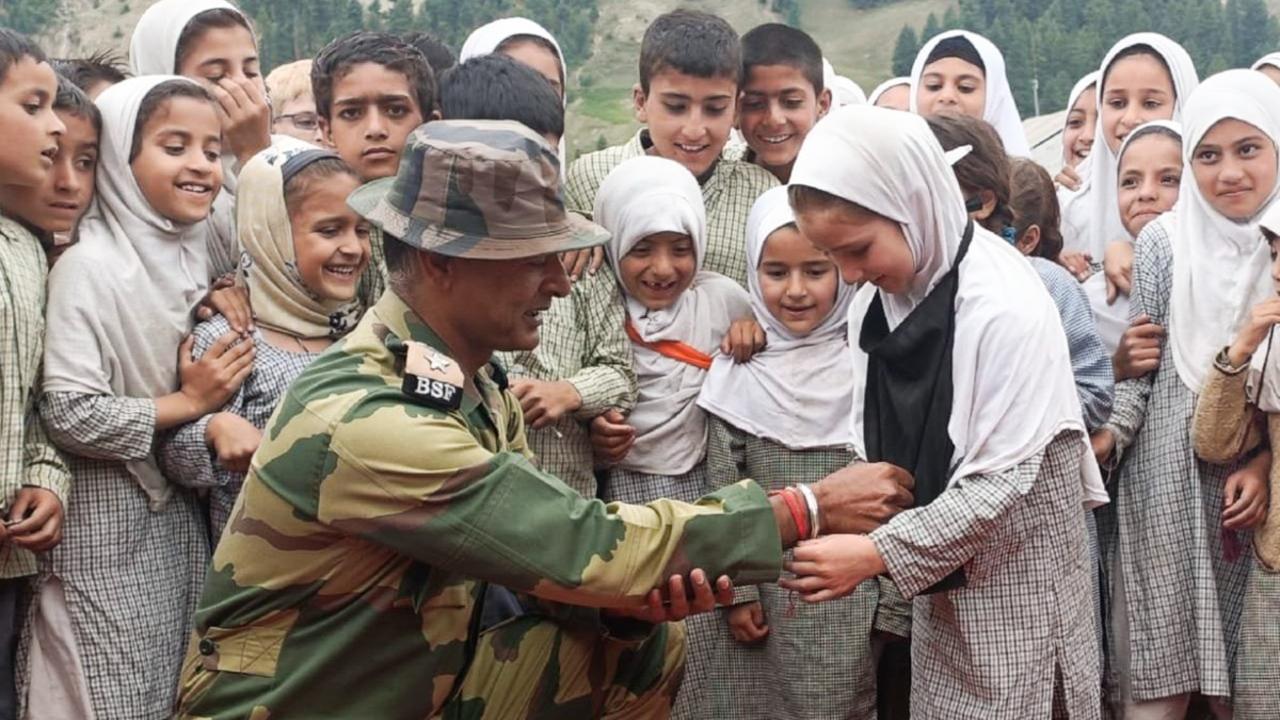Girls tie rakhi on the wrist of a BSF personnel on the occasion of Raksha Bandhan in Jammu and Kashmir (Pic: PTI)