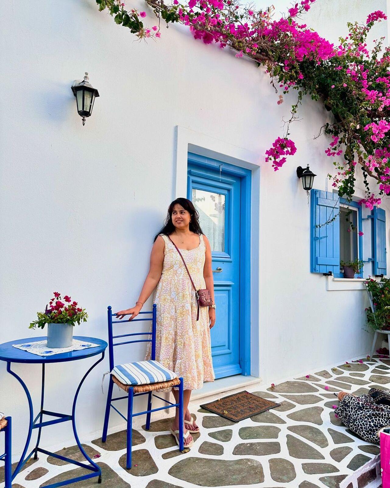 She posed in front of the white interiors, famous in Greece in a bespoke floral dress. 