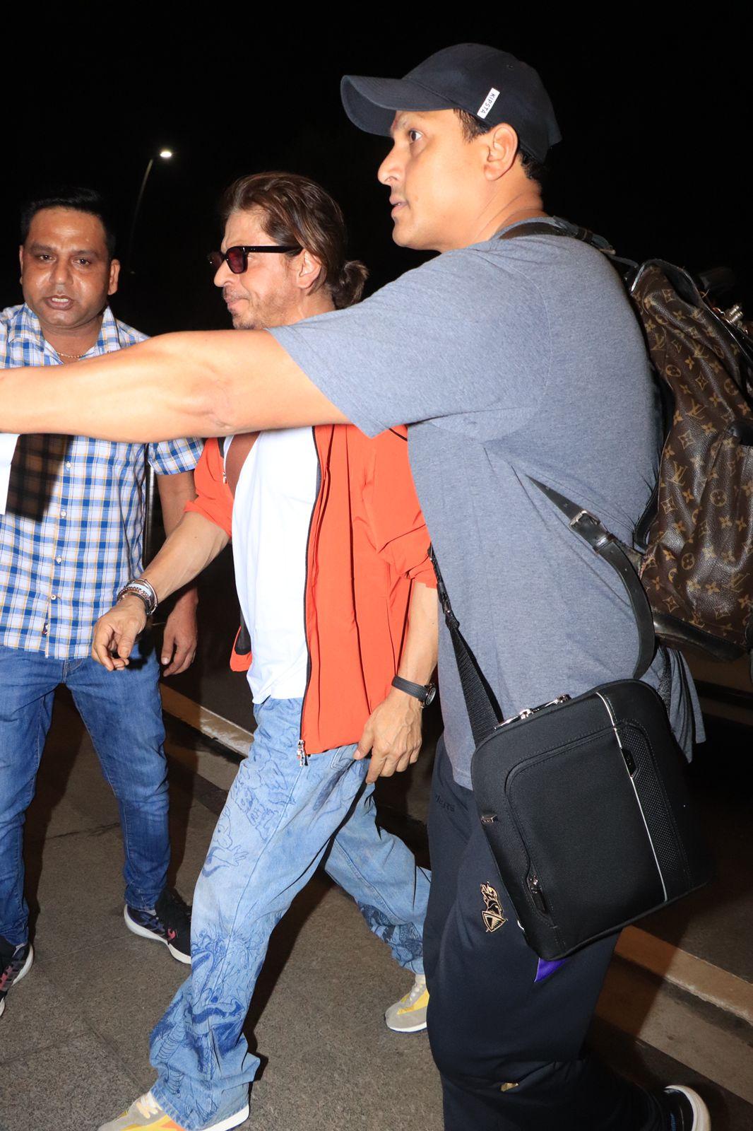 For his airport look, the 'Jawan' star opted for a cool choice. He wore a white T-shirt that he paired with an orange jacket and blue denims