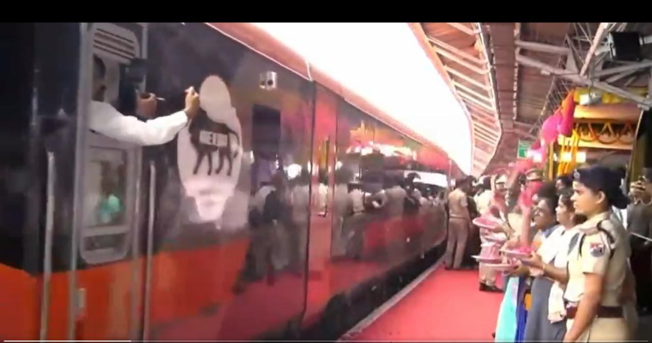 People shower flower petals on the Vande Bharat train that departed from Madurai to Bengaluru