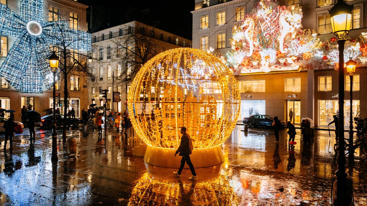 A pedestrian walks past Christmas lights on the Faubourg-Saint-Honore street in Paris 