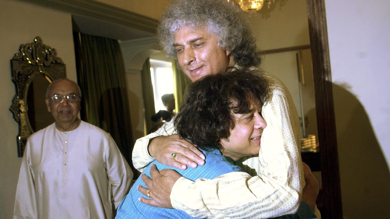 Zakir Hussain, Pandit Shivkumar Sharma and Arvind Parikh (standing behind) during a press conference for raising funds for the aid of tsunami victims