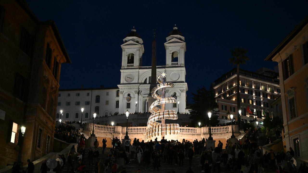 Visitors gather around a Christmas tree diplayed at the Spanish Steps, in front of the Trinita dei Monti in Rome