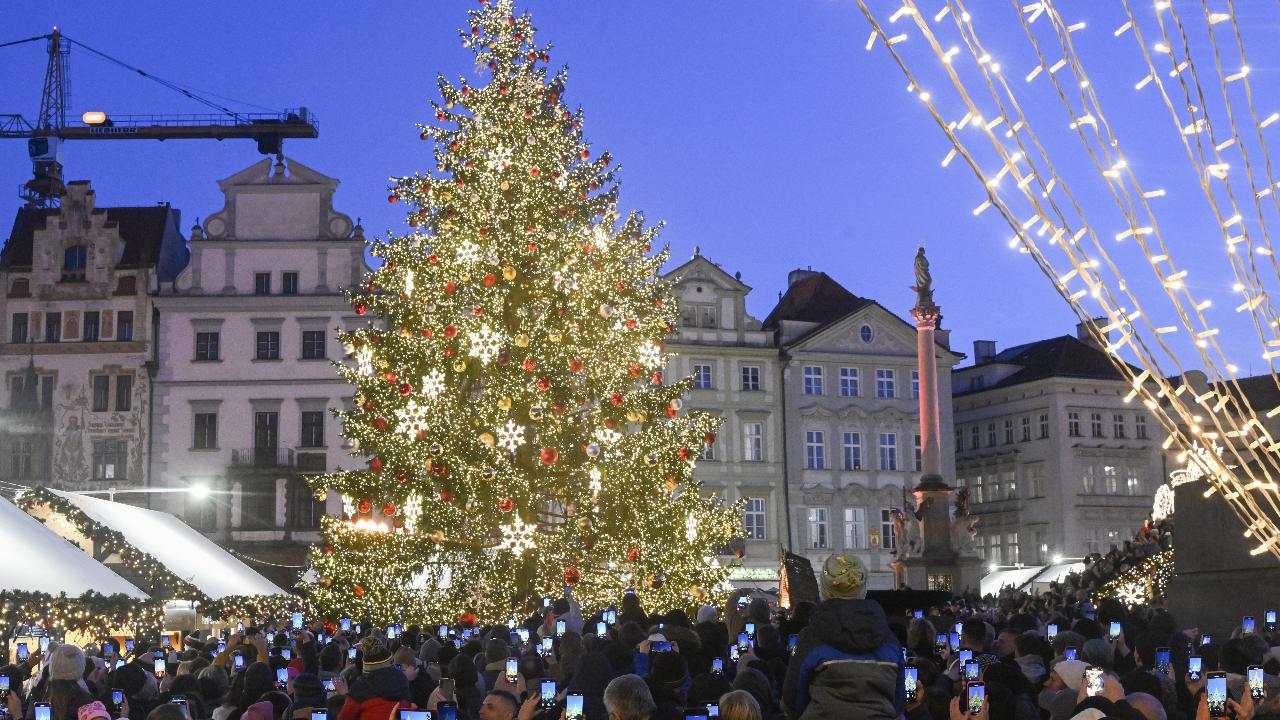 People take photos of the Christmas tree at the Christmas market at Old Town Square in Prague