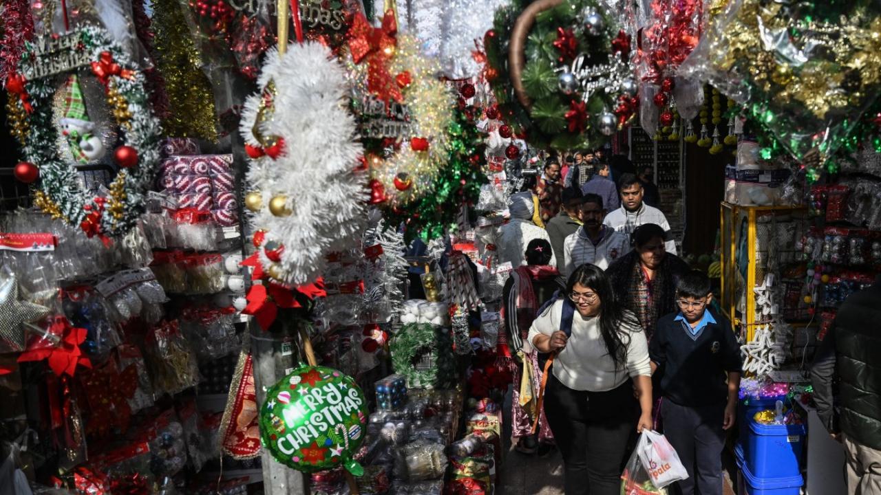 Shoppers walk past decorative items displayed at a market ahead of the Christmas celebrations in New Delhi (Pic: AFP)