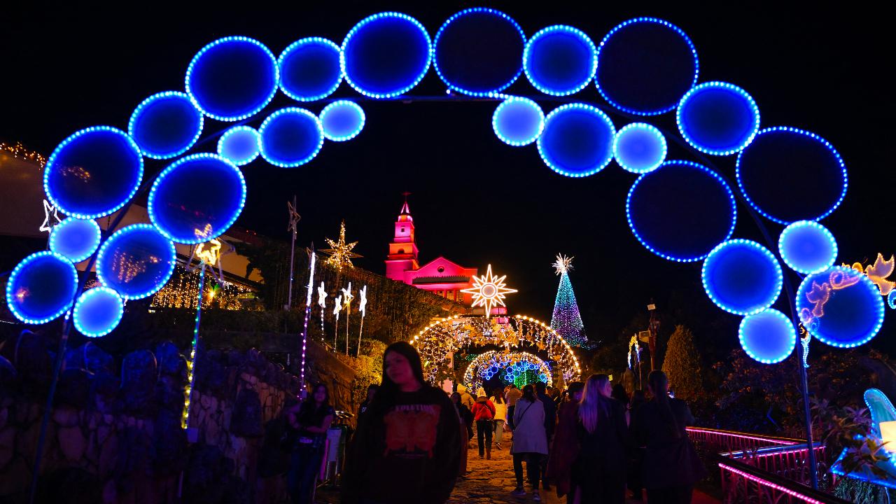 People walk past traditional Christmas lights at the Monserrate Mountain in Bogota, Colombia
