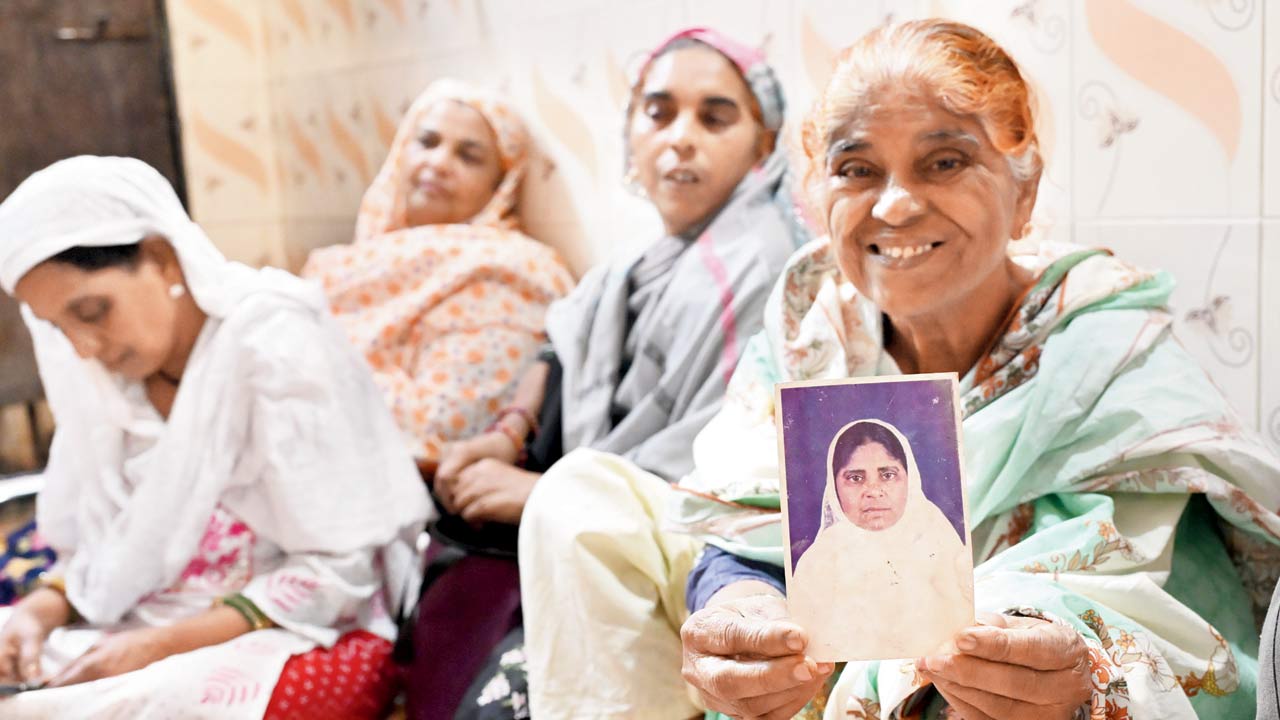 The 67-year-old holds up a picture of herself as a younger woman