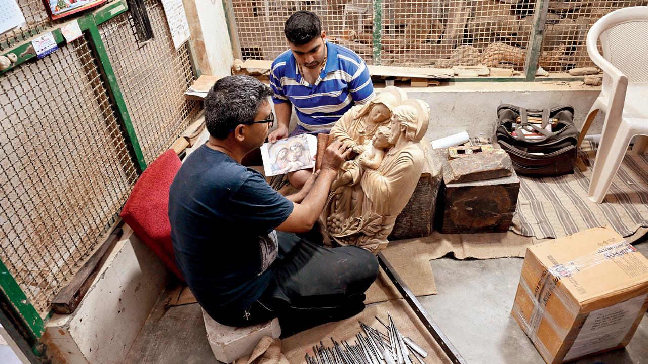 Benzoni (left) and Mark Sequeira work on a piece with an AI-generated reference picture