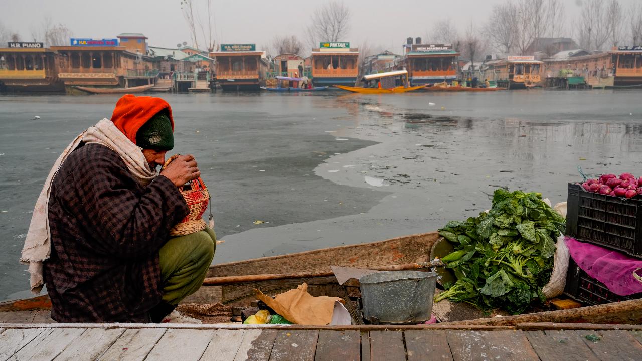 An elderly vendor sits on the banks of partially-frozen Dal Lake on a cold winter morning, in Srinagar on the same day, as temperatures dip to make it Srinagar's coldest December night since 1974, when the city recorded a low of minus 10.3 degrees Celsius, and the third coldest since 1891.