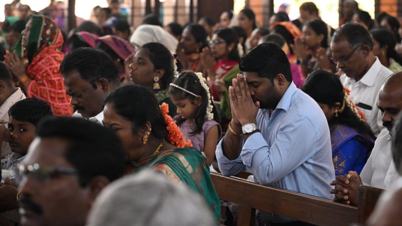Several devotees bow their heads in prayer, celebrating the birth of the Savior who brought light to the world