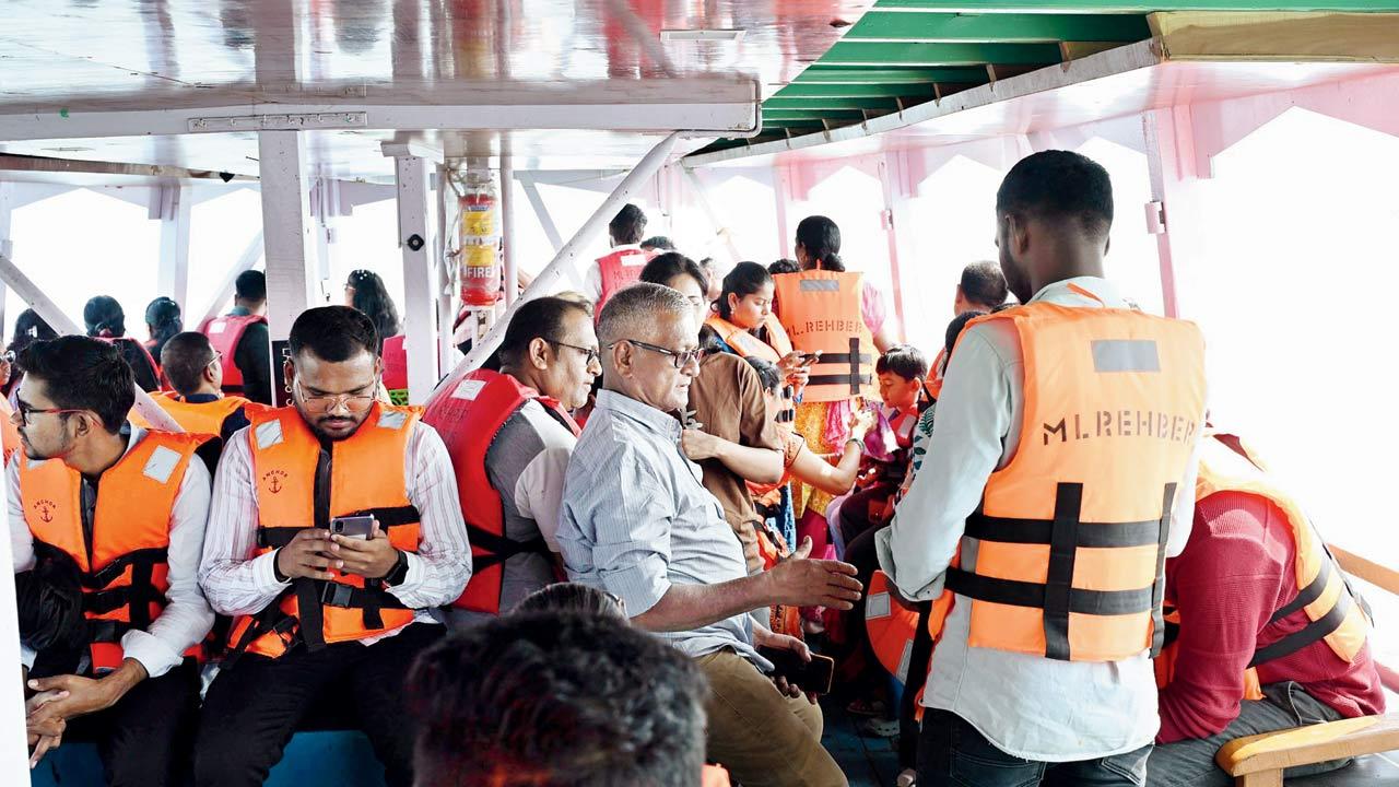 Boat crew members ensuring everyone aboard is wearing a life jacket. Pics/Sayyed Sameer Abedi