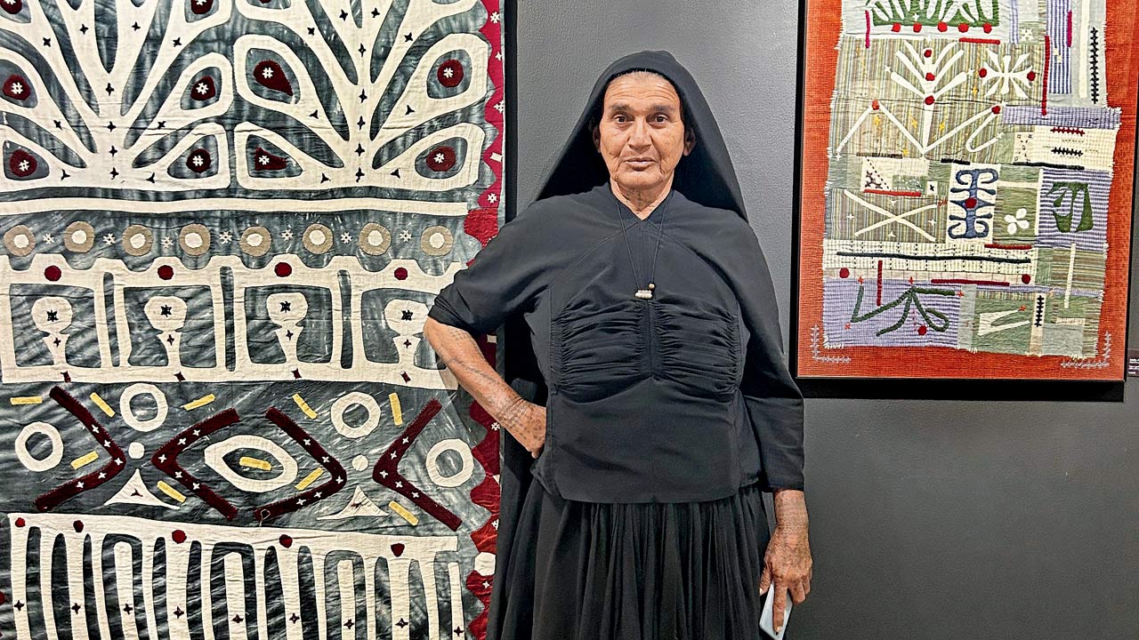 Kuvarben alongside one of her abstract applique creations