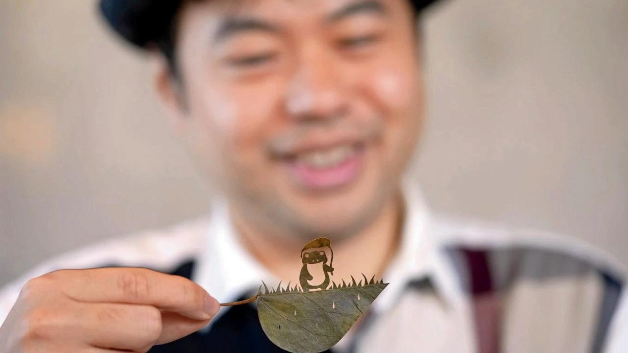 Japanese artist Lito looks at his freshly cut work featuring a frog with an umbrella. Pics/AP