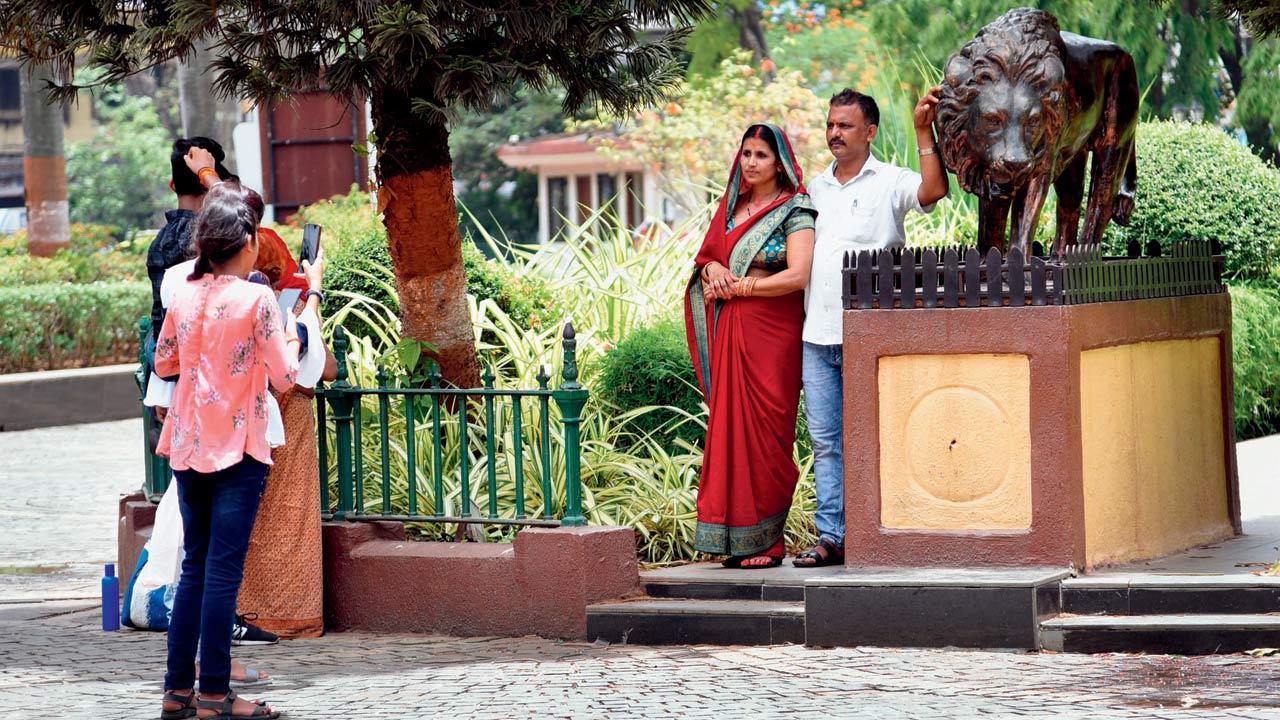 Visitors at Mumbai Zoo pose with a statue of an Asiatic lion. File pic