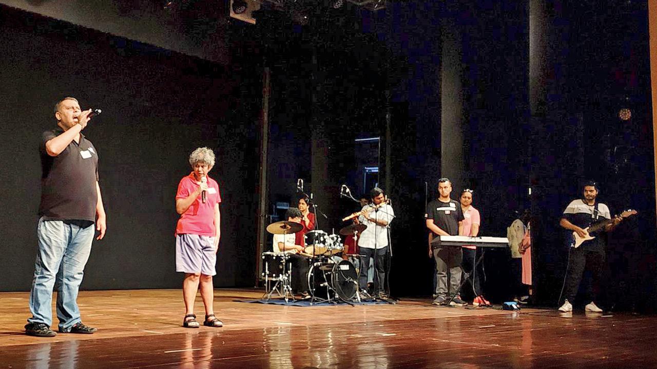 The troupe rehearses a song on stage
