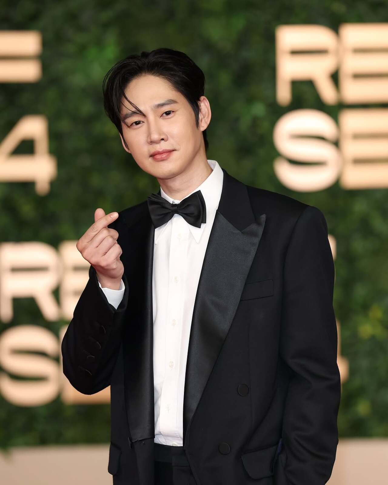 South Korean actor Park Sung-hoon makes a heart emoji on the red carpet