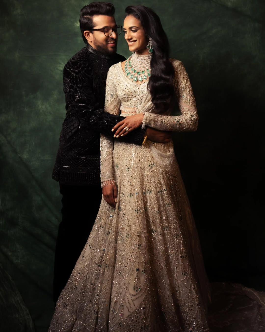 PV Sindhu dazzled at her reception in an ivory Falguni Shane Peacock lehenga adorned with Swarovski crystals and emerald accents, while Venkata Datta Sai looked dapper in a black velvet bandhgala
