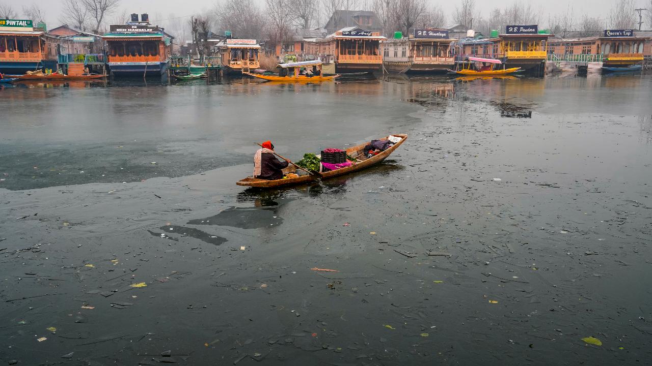 An elderly vendor rows his boat through partially-frozen Dal Lake on a cold winter morning, in Srinagar on Saturday. 'Chillai Kalan' will end on January 31 next year but the cold wave continues in the valley as it is followed by a 20-day 'Chillai-Khurd' (small cold) and a 10-day 'Chillai-Bachha' (baby cold).