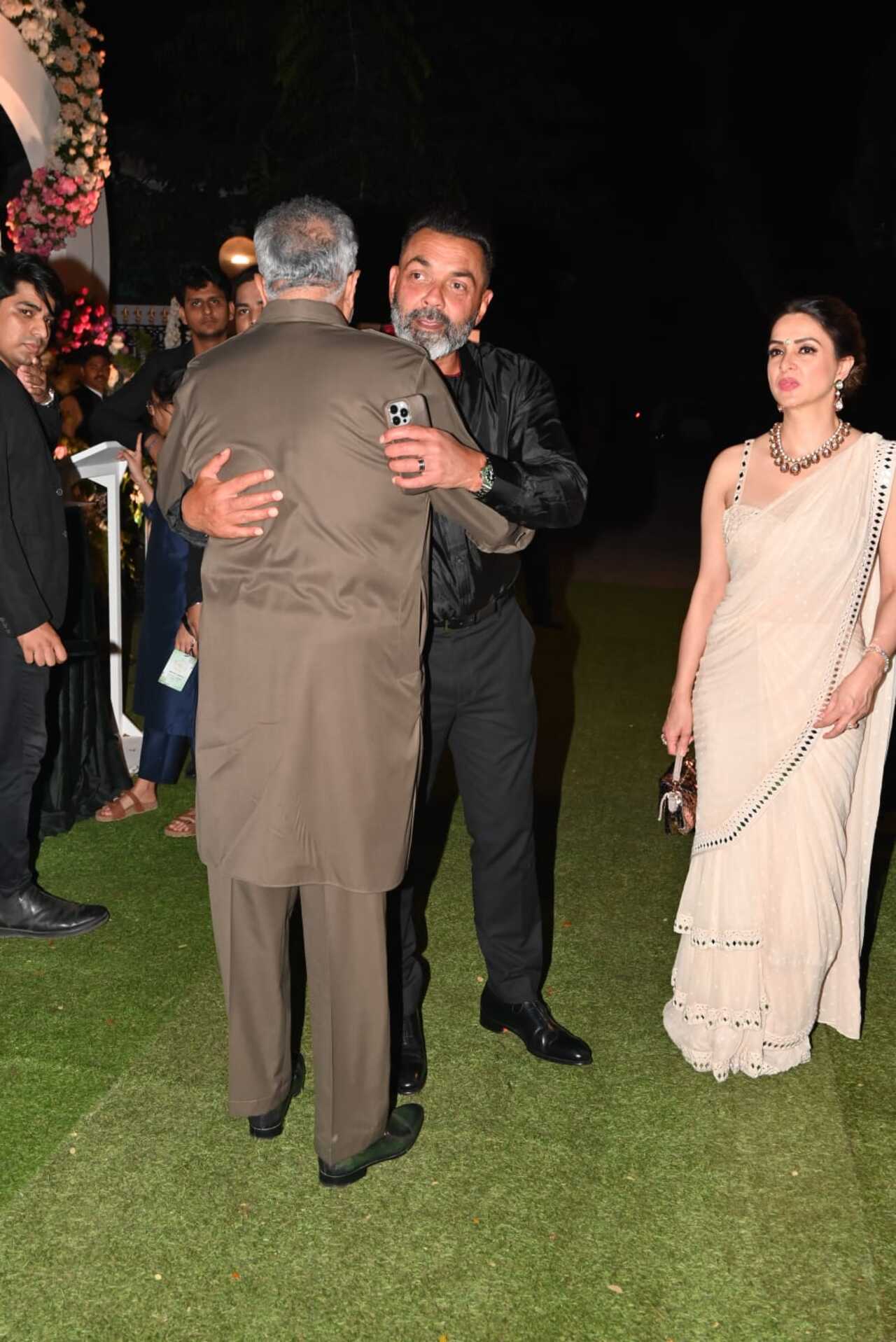 Filmmaker Boney Kapoor greets actor Bobby Deol with a warm hug as they meet outside the wedding venue