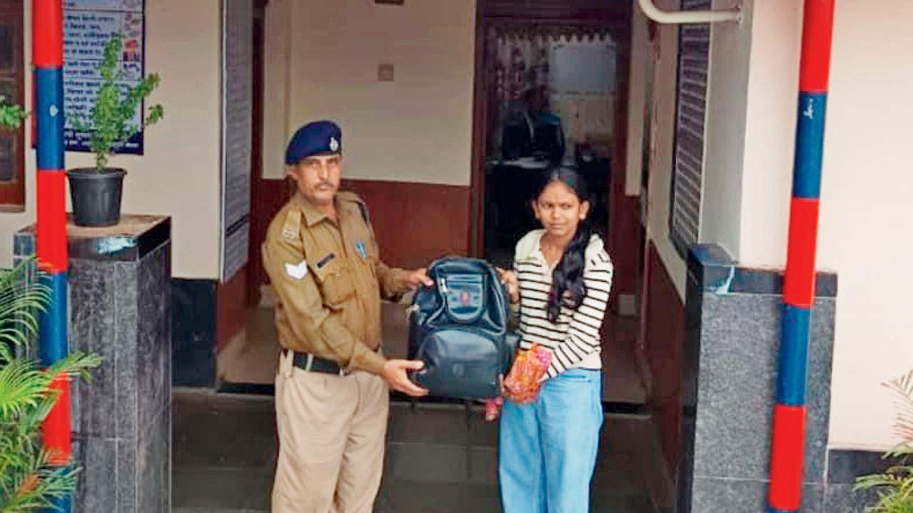 An RPF officer returning lost luggage to a passenger