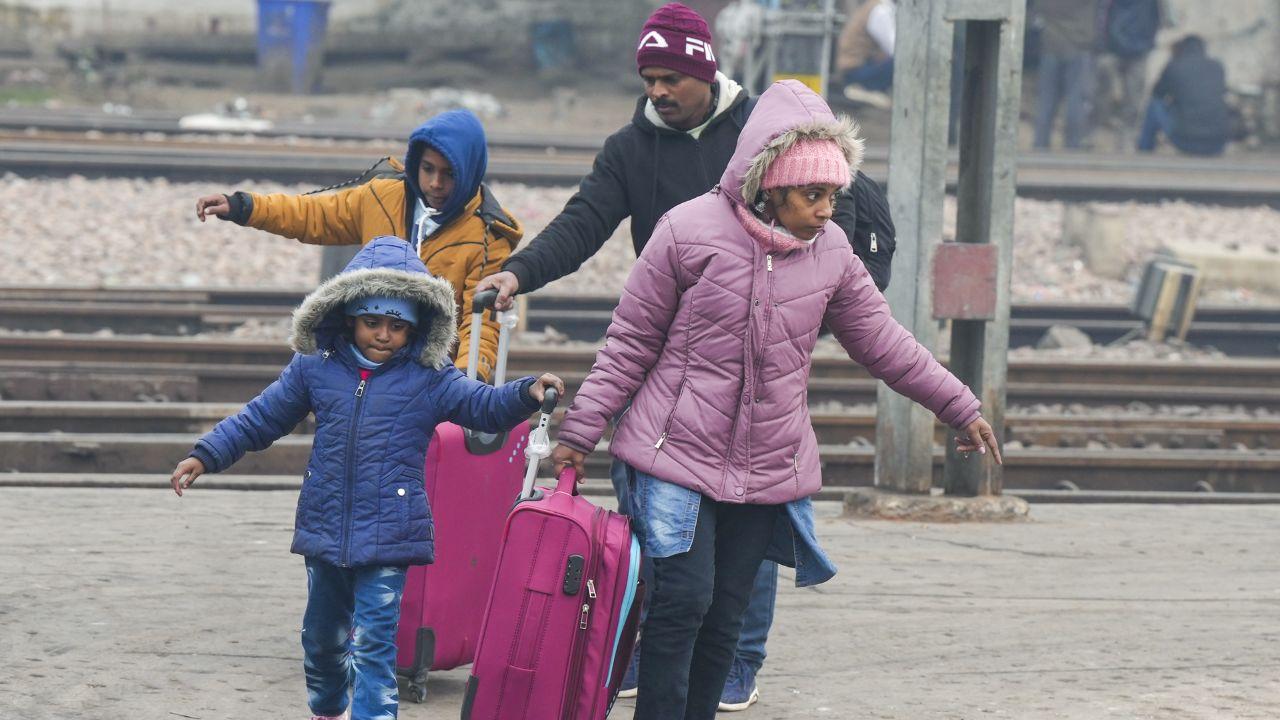 While others took refuge in night shelter homes as temperatures continued to drop in Delhi. (In Pics: People cross railway tracks on a cold winter day, in New Delhi on Monday)