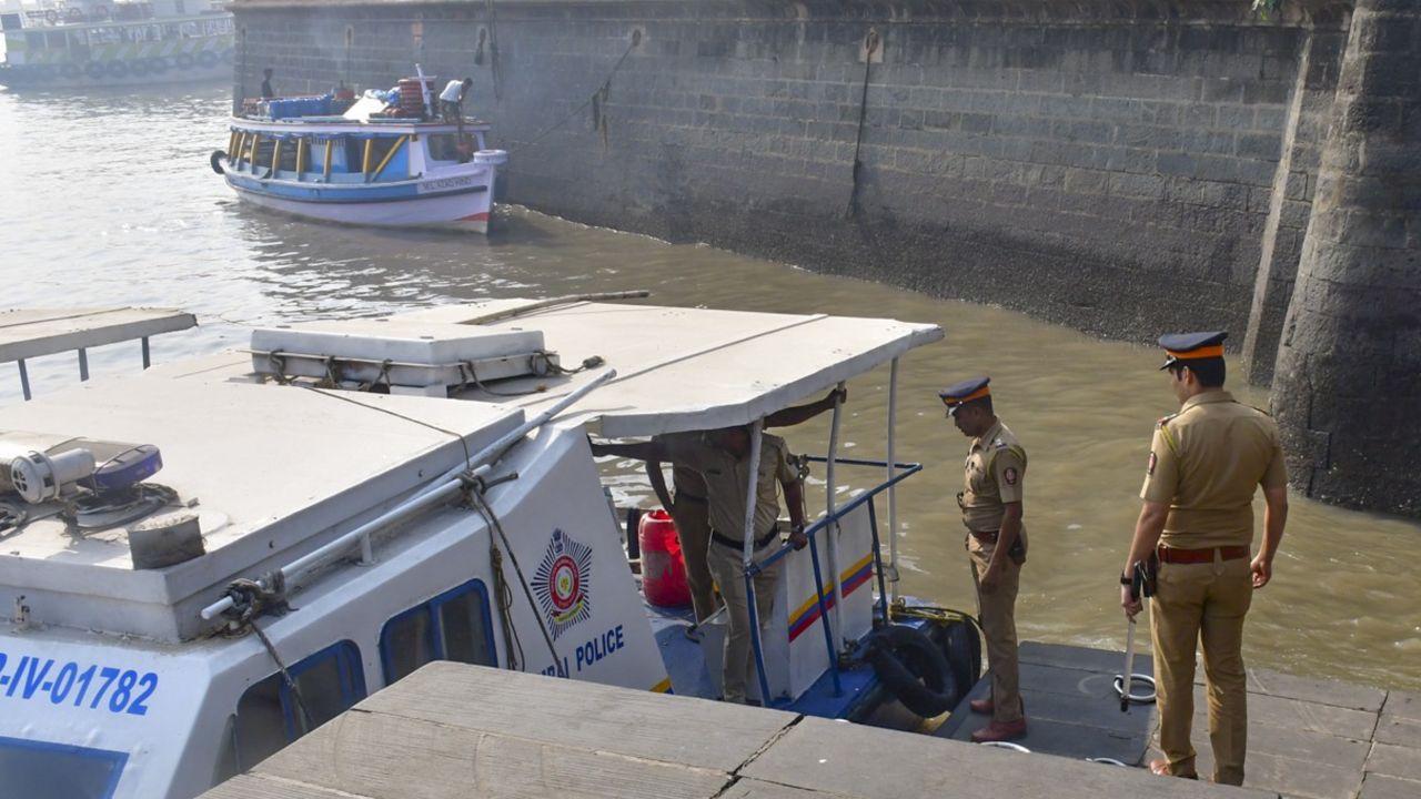 An Indian navy speedboat undergoing tests in the busy seas off in Mumbai lost control and slammed into a ferry, killing 13 people, the navy and government said on Wednesday. (In Pic: Police personnel keep vigil at the coast)