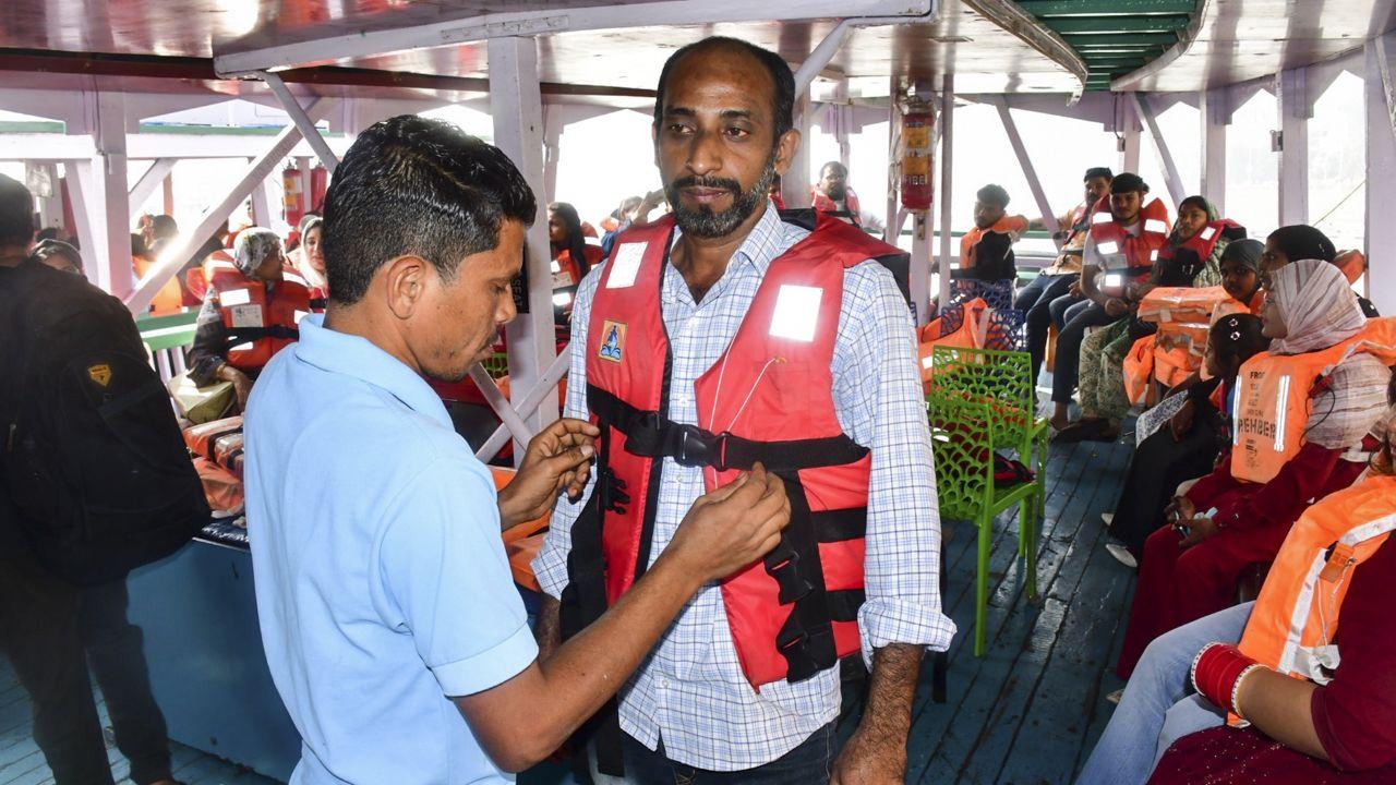 Of the 113 persons on board both the vessels, 13 died and 98, including two injured, were rescued. (In Pic: A passenger gets assisted to wear a life jacket following the distribution of life jackets to passengers)