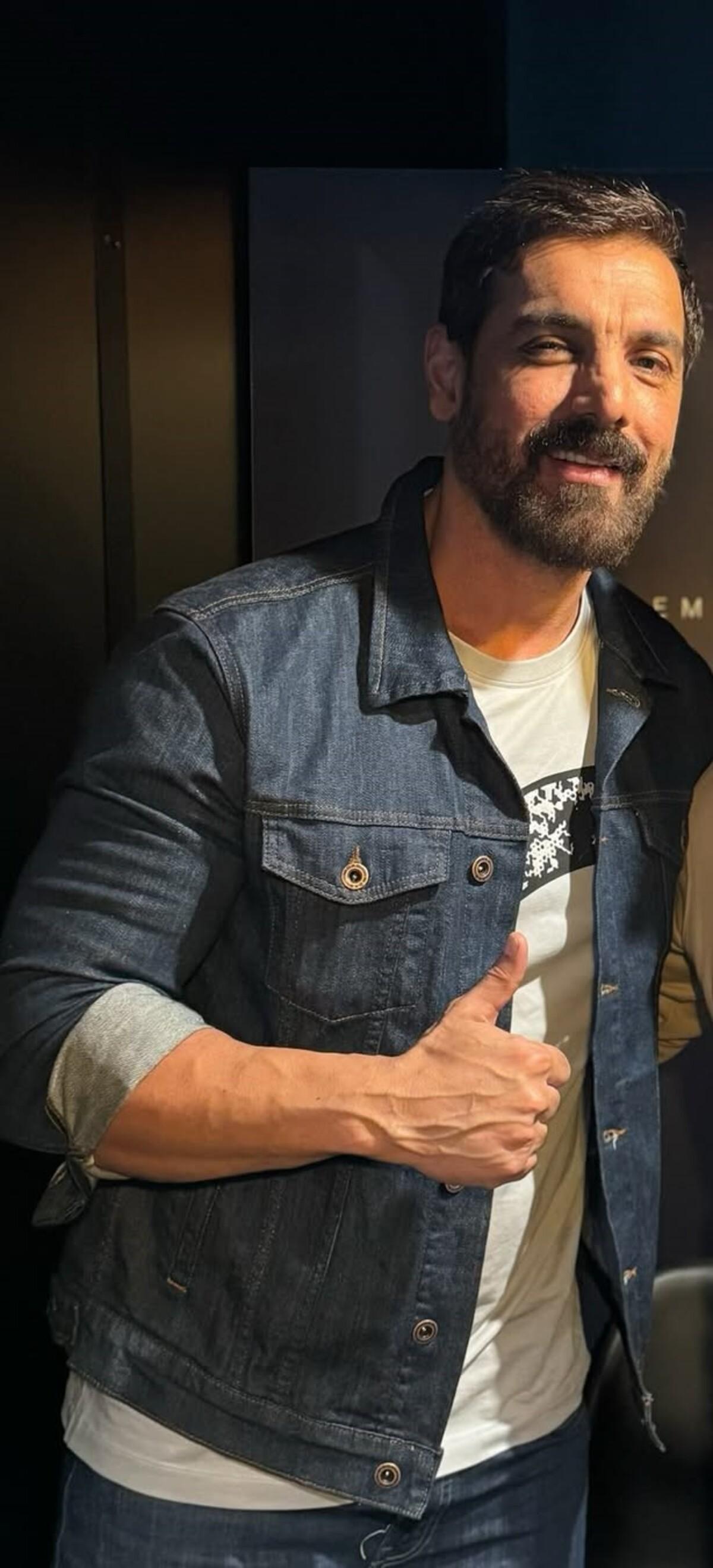 Looks like John loves to layer his clothes and jackets are his favourite. John pairs a dark blue denim jacket with a white tee and blue denims. This outfit accentuates his toned body and highlights his forearm muscles.
