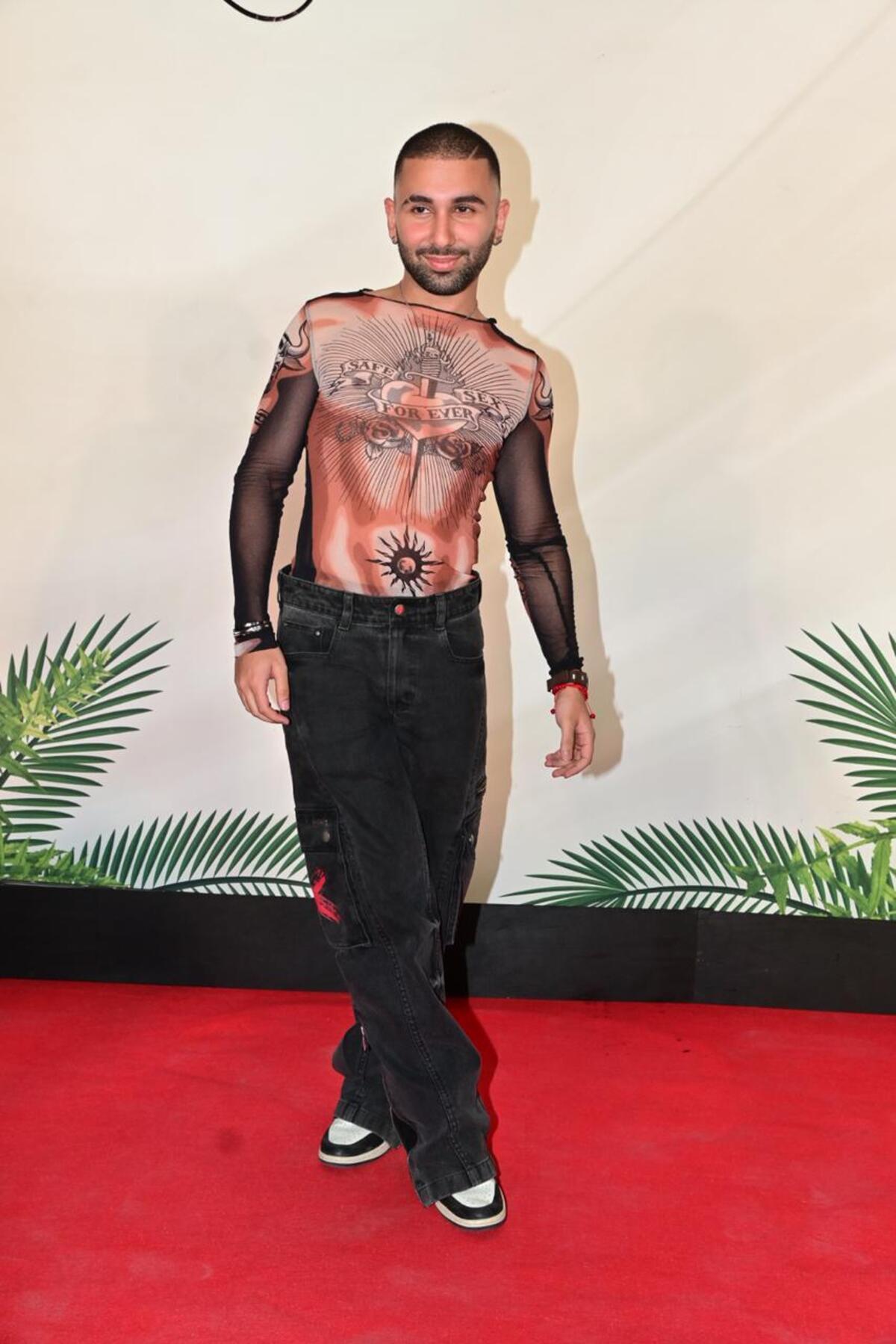 Orry was papped at Arpita Khan's new restaurant Mercii. He was wearing a sheer black and orange graphic top. He paired it with black wide-legged jeans.